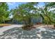 Charming home exterior with lush landscaping, mature trees, and a paved driveway at 5282 Box Turtle Cir, Sarasota, FL 34232