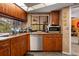 Well-lit kitchen featuring wood cabinetry, stainless steel appliances, and a view of the outdoor pool area at 5282 Box Turtle Cir, Sarasota, FL 34232