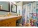 Bathroom featuring oak vanity with beige countertop and a shower with an ocean-themed shower curtain at 5346 Neil Dr, St Petersburg, FL 33714