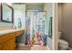 Bathroom featuring oak vanity with a beige countertop and a shower with an ocean-themed shower curtain at 5346 Neil Dr, St Petersburg, FL 33714