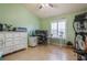Bedroom featuring light green walls, tile floors, ceiling fan, workspace with desk, and exercise equipment at 5346 Neil Dr, St Petersburg, FL 33714