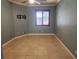 An empty bedroom featuring neutral paint, tile flooring, and window with natural light for versatility at 5346 Neil Dr, St Petersburg, FL 33714
