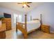 Bedroom with tile floors, light purple walls, ceiling fan, a wooden bed, and wood dresser and nightstand at 5346 Neil Dr, St Petersburg, FL 33714