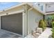 Attached garage with a brown garage door, lighting fixture, and well-maintained landscaping at 5346 Neil Dr, St Petersburg, FL 33714