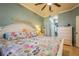 Bright main bedroom features colorful bedding, white furniture, ceiling fan, and adjoining bathroom at 5346 Neil Dr, St Petersburg, FL 33714
