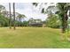 Expansive backyard featuring lush greenery and a screened-in lanai area at 5533 Ashley Pkwy, Sarasota, FL 34241
