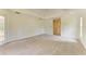 Carpeted bedroom featuring tray ceilings, white walls and a glass door leading to the backyard at 5533 Ashley Pkwy, Sarasota, FL 34241