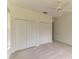 Bedroom featuring neutral carpeting, ceiling fan, and double door closets at 5533 Ashley Pkwy, Sarasota, FL 34241
