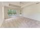 Carpeted bedroom with ceiling fan, tray ceilings and natural light from the large window at 5533 Ashley Pkwy, Sarasota, FL 34241