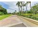 Long, winding driveway leading to a home, lined with manicured landscaping and mature palm trees at 5533 Ashley Pkwy, Sarasota, FL 34241