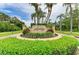 Inviting community entrance with lush landscaping, palm trees, and elegant signage, creating a grand welcome at 5533 Ashley Pkwy, Sarasota, FL 34241