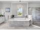 Luxurious bathroom with a soaking tub, large window, and glass-enclosed shower at 603 165Th E St, Bradenton, FL 34212
