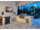 This outdoor kitchen features granite countertops, a built-in grill, and a refrigerator beneath a TV at 603 165Th E St, Bradenton, FL 34212