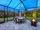 Night view of the covered patio featuring an outdoor dining area and fire pit at 603 165Th E St, Bradenton, FL 34212