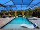 This screened-in pool features a lounge, spa, waterfall, outdoor kitchen, dining, and a basketball hoop at 603 165Th E St, Bradenton, FL 34212