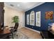 Elegant home office with natural light, a modern desk setup, and stylish dark blue accent wall at 6231 Cypress Bend Ct, University Park, FL 34201