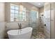 Stunning bathroom featuring a soaking tub, walk-in shower, and unique glass block windows for natural light at 6231 Cypress Bend Ct, University Park, FL 34201