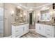 Elegant bathroom showcasing dual granite countertop vanities, walk-in shower and decorative mirrors at 6231 Cypress Bend Ct, University Park, FL 34201