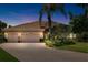 Charming home featuring a three-car garage, tile roof, brick driveway, and well-maintained landscaping and lawn at 6231 Cypress Bend Ct, University Park, FL 34201