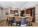Modern kitchen with custom cabinets, granite countertops, a stainless steel hood, and an eat-in island at 6231 Cypress Bend Ct, University Park, FL 34201