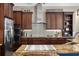 Gourmet kitchen with stainless steel appliances, custom cabinets, granite countertops, and a stylish tile backsplash at 6231 Cypress Bend Ct, University Park, FL 34201