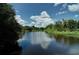 Calm lake view showcasing a clear reflection of the sky with lush greenery along the shoreline at 6231 Cypress Bend Ct, University Park, FL 34201