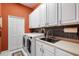 Functional laundry room featuring modern washer/dryer, sink, and ample cabinet space at 6231 Cypress Bend Ct, University Park, FL 34201
