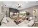 Bright living room boasts a ceiling fan, a stylish entertainment center and sliding door access to a pool at 6231 Cypress Bend Ct, University Park, FL 34201