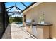 Outdoor kitchen with grill and beverage fridge, perfect for enjoying poolside gatherings at 6231 Cypress Bend Ct, University Park, FL 34201