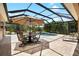 Relaxing screened-in pool area with patio dining and lounge chairs, perfect for entertaining guests at 6231 Cypress Bend Ct, University Park, FL 34201