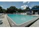 Community swimming pool featuring a light blue liner, lounge chairs, and a shaded patio at 6231 Cypress Bend Ct, University Park, FL 34201