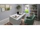 Well-lit home office featuring a white desk, green chair, and a view to the outdoors at 6384 Grayson St, Englewood, FL 34224