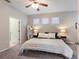 Bright bedroom featuring a ceiling fan, plush carpet, and three windows for natural light at 6523 Blue Grosbeak Cir, Lakewood Ranch, FL 34202