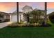 Charming home exterior with lush landscaping, a well-manicured lawn, and a two-car garage at 6523 Blue Grosbeak Cir, Lakewood Ranch, FL 34202
