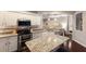 Open kitchen featuring granite countertops, stainless steel appliances, and an island with breakfast seating at 6523 Blue Grosbeak Cir, Lakewood Ranch, FL 34202