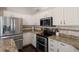 This kitchen showcases stainless steel appliances, granite countertops, and custom tile backsplash at 6523 Blue Grosbeak Cir, Lakewood Ranch, FL 34202