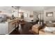 Open concept kitchen and living room with barstool seating, stainless steel appliances, and hardwood floors at 6523 Blue Grosbeak Cir, Lakewood Ranch, FL 34202