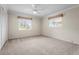 Bedroom featuring neutral carpet, two windows, ceiling fan and closet with folding doors at 7391 W Country Club N Dr, Sarasota, FL 34243
