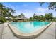 Large, inviting community pool surrounded by mature trees, landscaping and lounge chairs for relaxation at 7391 W Country Club N Dr, Sarasota, FL 34243