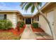 Well-manicured front entrance with a colorful garden and elegant double front door at 7391 W Country Club N Dr, Sarasota, FL 34243