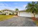 Charming single Gathering home featuring a spacious two-car garage and tropical landscaping at 7391 W Country Club N Dr, Sarasota, FL 34243