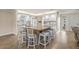 Bright kitchen featuring white cabinets, granite counters, and a large island with bar seating at 7391 W Country Club N Dr, Sarasota, FL 34243