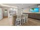 Bright open kitchen with white cabinets, granite counters, and a large island with bar seating at 7391 W Country Club N Dr, Sarasota, FL 34243