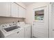 Laundry room with new washer/dryer, white cabinets, and outside access door at 7391 W Country Club N Dr, Sarasota, FL 34243