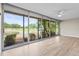 Enclosed sunroom with walls of sliding glass doors overlooks tranquil pond and verdant landscape at 7391 W Country Club N Dr, Sarasota, FL 34243