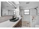 Modern bathroom with a black vessel sink, pebble floor shower, and white subway tile walls at 801 E 5Th St, Englewood, FL 34223