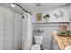 Updated bathroom with tiled shower, white vanity, wood countertop, and coastal-themed decor at 801 E 5Th St, Englewood, FL 34223