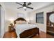 Cozy bedroom with a queen sized bed, ceiling fan, dark wood floors, and bright natural light at 801 E 5Th St, Englewood, FL 34223
