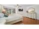 Bright bedroom with hardwood floors, ceiling fan, TV, dresser, and slider doors to the backyard at 801 E 5Th St, Englewood, FL 34223