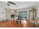 Bright dining area adjacent to the living room and pool, with fireplace, hardwood floors, and sliding glass doors at 801 E 5Th St, Englewood, FL 34223